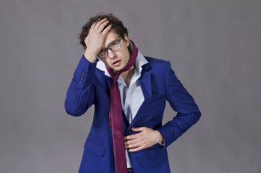 Genç çocuk içinde giyen takım elbise, kravat ve gözlük ile kötü hissediyor