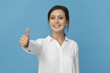 Ok hareketi ile mavi boş duvara poz beyaz T-shirt giyen olumlu erkek çekici görünüm ile gülümseyen