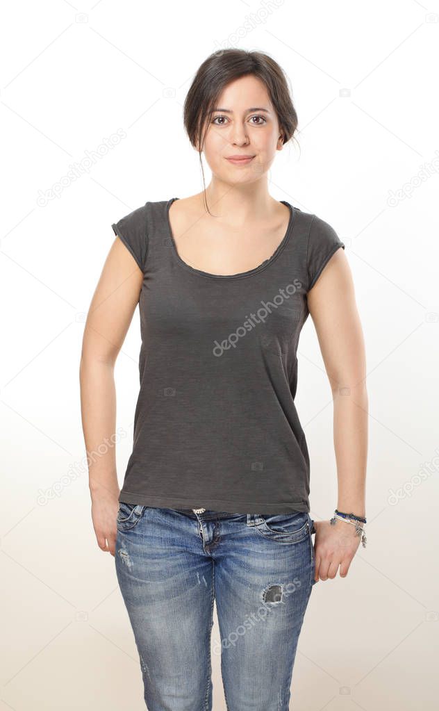Nice brunette woman in T-shirt and jeans keeping hands in her pockets
