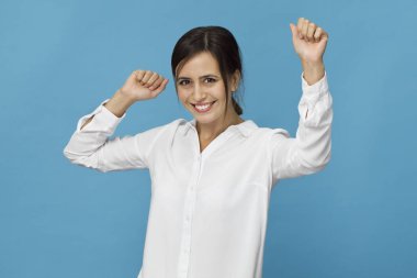 Mavi arka planı gülümseyerek mutlu bir genç kadın