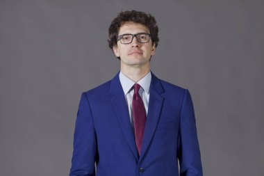 Mavi takım ve gözlük gülümseyen genç adam