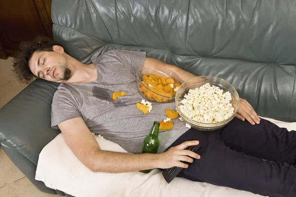 Een Man Slapen Een Bank Een Puinhoop Van Junk Food — Stockfoto