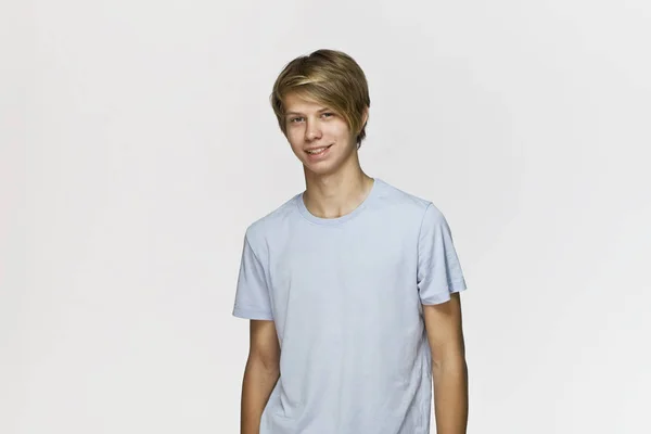 英俊快乐微笑的年轻人穿着蓝色 T恤工作室肖像反对白色墙壁 — 图库照片