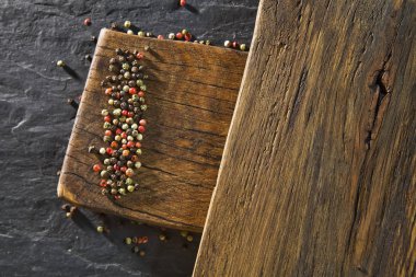 Ahşap masa ve siyah tablo arka plan üzerinde renkli biber üstten görünüm