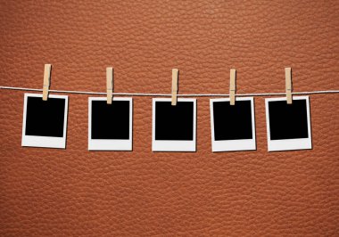 Arka planda çamaşır ipinde asılı eski resim çerçevesi.