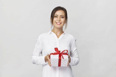 Mutlu genç iş kadını bir hediye kutusu, beyaz zemin üzerine kırmızı kurdele ile.