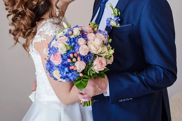 Mavi elbiseli bir damat ve gelin beyaz elbiseli güzel bir tutun çok renkli buket düğün portre çiçekler