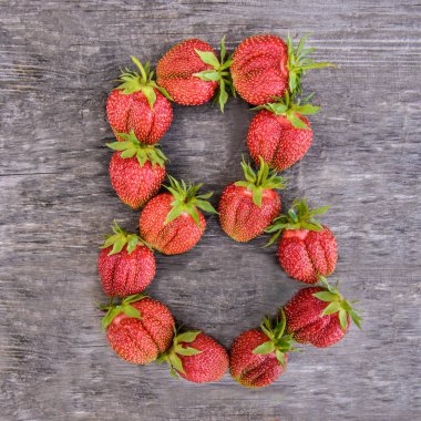 En büyük tatlı lezzetli olgun kırmızı çilek ahşap rustik arka plan üzerinde sayısı sekiz 8