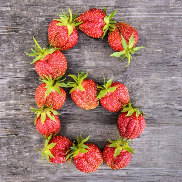 En büyük tatlı lezzetli olgun kırmızı çilek ahşap rustik arka plan üzerinde altı 6 sayısı