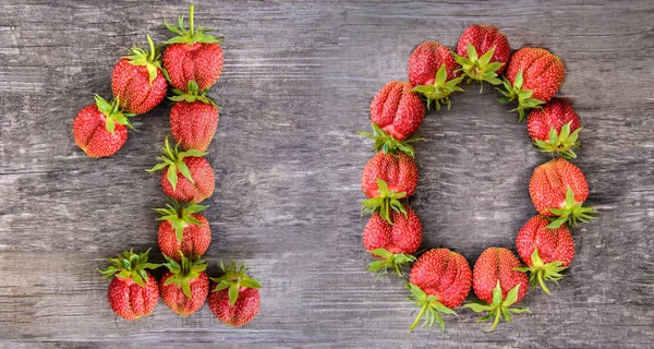 The number 10 of the largest sweet delicious strawberries on wooden background