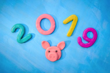Hamuru numarası 2019 yılı - mavi bir arka plan üzerinde pembe bir domuz sembolü ile yeni yıl çok renkli