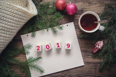 Güzel Noel kartı ile yeni yıl 2019, ağaç dalları, toplar, eşarp, ahşap rustik zemin, kopya alanı, üstten görünüm üzerine çay