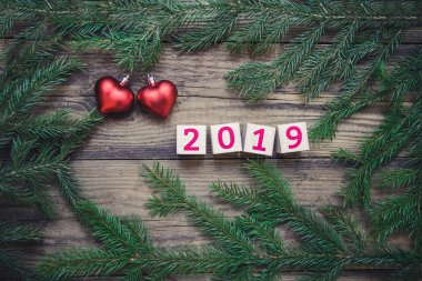 Güzel kart yeni yıl 2019 ve Noel ağacı dalları ile ahşap rustik zemin, kopya alanı, üstten görünüm üzerine iki kırmızı kalp