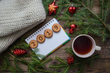 Yeni yıl resmi Noel ağaç dalları ve ahşap arka plan üzerinde sıcak çay bir fincan ile yuvarlak tanımlama bilgisi 2019 numarası