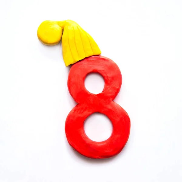 Красный Пластилин Номер Восемь Желтой Зимней Шапке Белом Фоне — стоковое фото