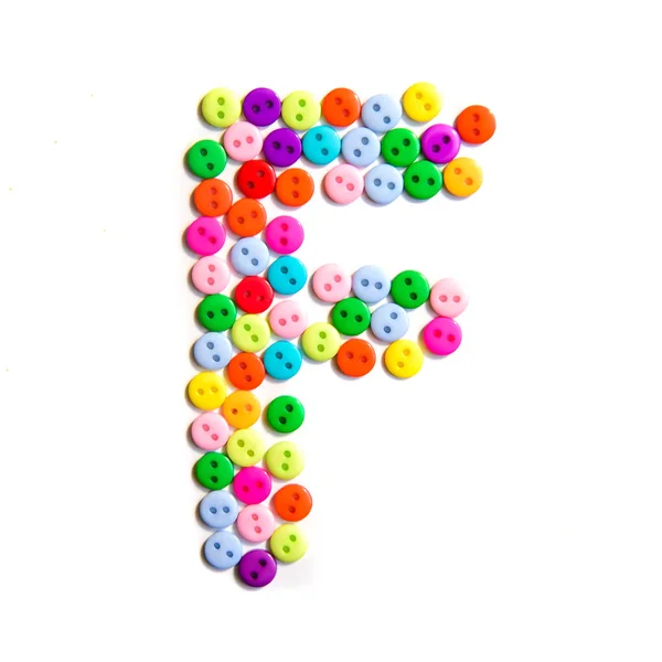 Буква F английского habet сделана из разноцветных пуговиц — стоковое фото