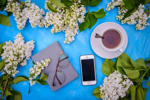 Beyaz Eflatun Dalları Cep Telefonu Kitap Bardak Çay Mavi Arka — Stok fotoğraf