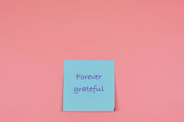 Önplanda teşekkür sözcüğü ve pembe arkaplanda kopyalama alanı olan yapışkan bir not