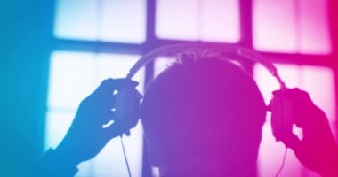 Mavi Pembe Renkli DJ Yavaş Çekimde Kulaklık takıyor. Uçan Soyut Notalar Hologram Simgeleriyle Müzik Dinliyorum. Ses Tasarımı Konsepti. 4K UHD 4096x2160 3d animasyon.