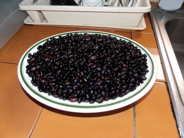 Mutfakta bir plaka üzerinde ham siyah fasulye