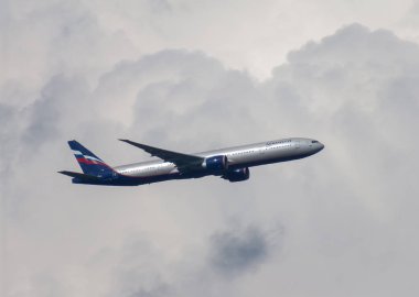 Bir büyük kümülüs bulut önünde bir güzel yaz gününde görülen Aeroflot Boeing B777-300er uçak uçan