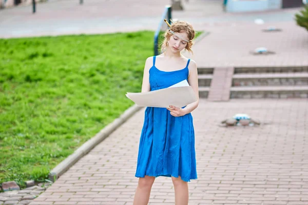 Belle fille-artiste dans la rue en robe bleue dessine un croquis de l'image — Photo