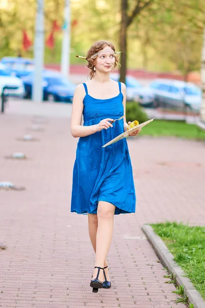 Bella ragazza-artista per strada in abito blu, sorridente, con nappe e tavolozza in mano — Foto Stock