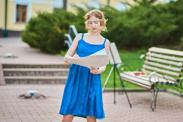 美丽的女孩-艺术家在街上的蓝色礼服画素描的图片 — 图库照片