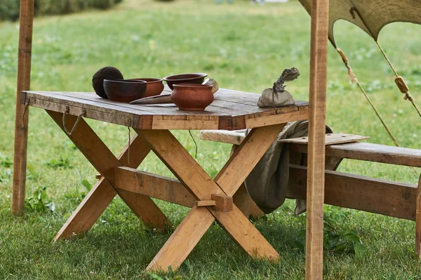 Medeltida trä köksredskap, placeras på ett stort träbord — Stockfoto