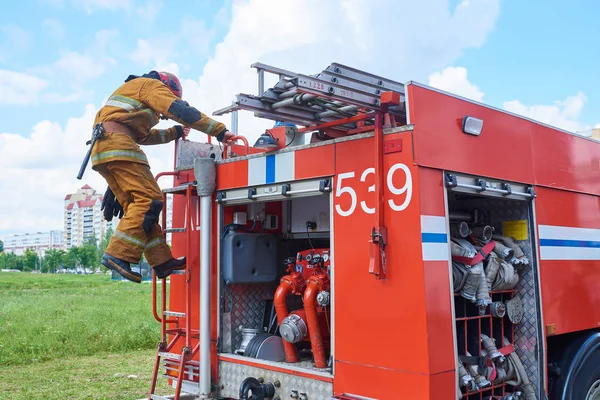 Firefighter down the fire truck on the stairs for any purpose — Stock Photo, Image