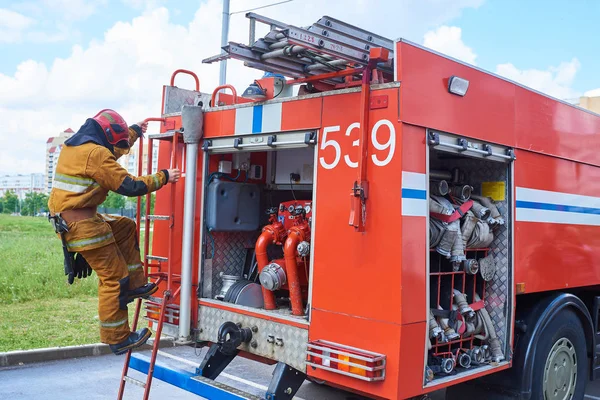 Firefighter down the fire truck on the stairs — Stock Photo, Image