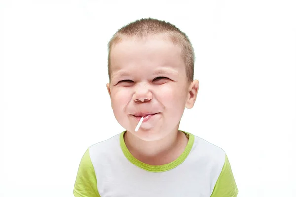 Un niño pequeño con un bastón de caramelo en la boca . — Foto de Stock