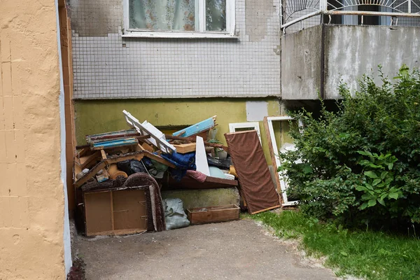 Een grote stapel vuilnis onder de ramen van een huis — Stockfoto