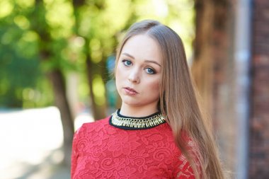 Kırmızı elbiseli güzel sarışın bir kızın portresi.