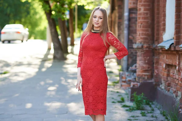 Schöne blonde Mädchen in rotem Kleid auf einem Spaziergang im Park — Stockfoto