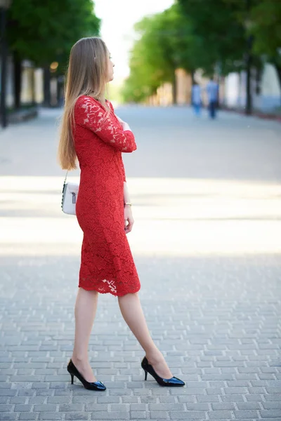 Bella ragazza bionda in abito rosso su una passeggiata nel parco — Foto Stock