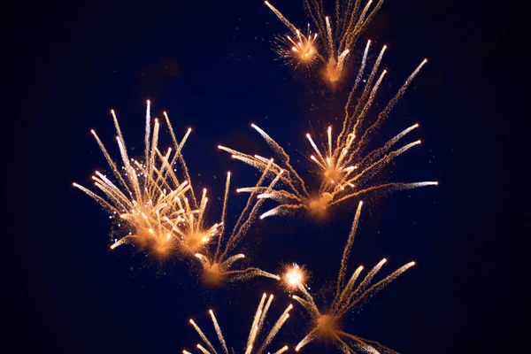 Goedkope heldere sprankelende vuurwerk van wit-gele kleur, tegen de nachtelijke hemel — Stockfoto