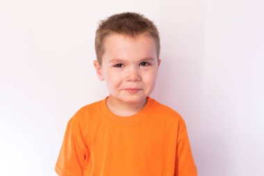 Parlak bir arka plan karşı üzgün yüzü ile Sevimli küçük çocuk