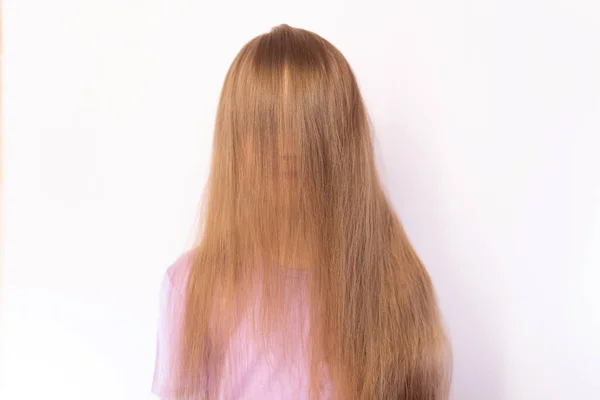 La petite fille fermée par les cheveux long visage, fond clair — Photo