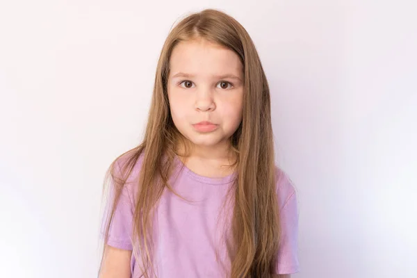 Mała śliczna dziewczyna z smutnym wyrazem na twarzy, na jasnym tle — Zdjęcie stockowe
