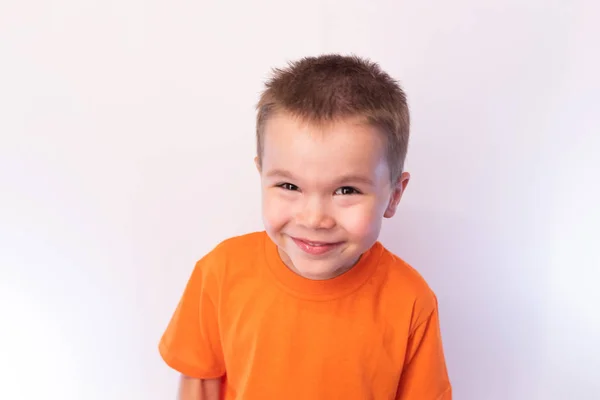 Маленький милый мальчик в яркой рубашке, улыбающийся, на светлом фоне — стоковое фото