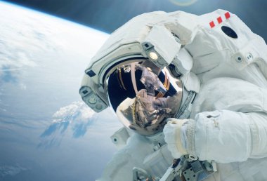 Astronot bir dış uzayda, dünyanın arka planına karşı, bir uzay giysisi içinde. Bu görüntünün unsurları Nasa tarafından döşenmiştir