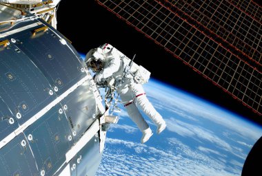 Uzaydaki astronot, Iss'te, onarıyor ve deneyler yapıyor. Bu görüntünün unsurları Nasa tarafından döşenmiştir