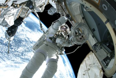 Uzay giysisi giyen astronot, uzay istasyonunun onarımı yla meşgul. Bu görüntünün unsurları Nasa tarafından döşenmiştir