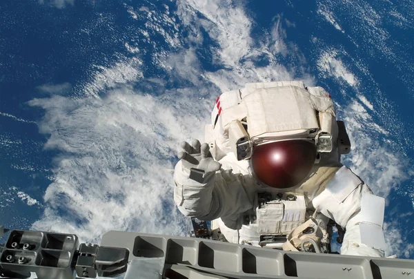 Astronaut i en rymddräkt, vågor en hand, på rymdstationen, i ett yttre rymden. Delar av denna bild möblerades av NASA — Stockfoto