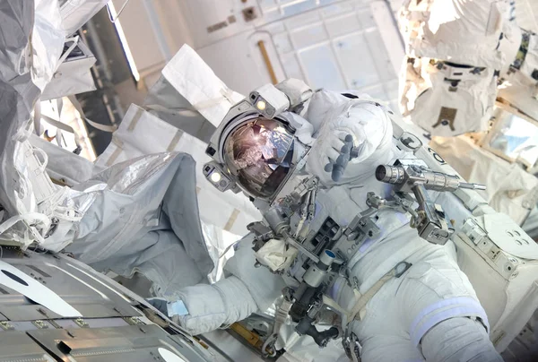 Astronauten i en rymddräkt, i ISS, håller en hand i kameran. Delar av denna bild möblerades av NASA — Stockfoto