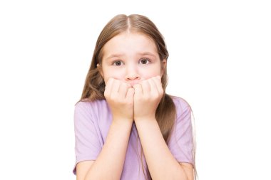 Küçük kız korktu ve yumruklarını yüzüne dayadı. Beyaz arka planda yalıtılmış.