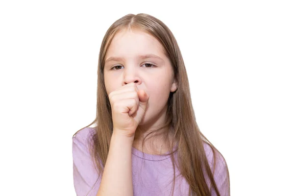 La niña tose fuertemente en un puño está aislada sobre un fondo blanco . — Foto de Stock