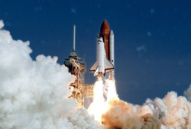 Uzay mekiğinin fırlatılması. Ateş ve dumanla. Yıldızlı gökyüzünün arka planına karşı. Bu görüntünün unsurları Nasa tarafından döşenmiştir