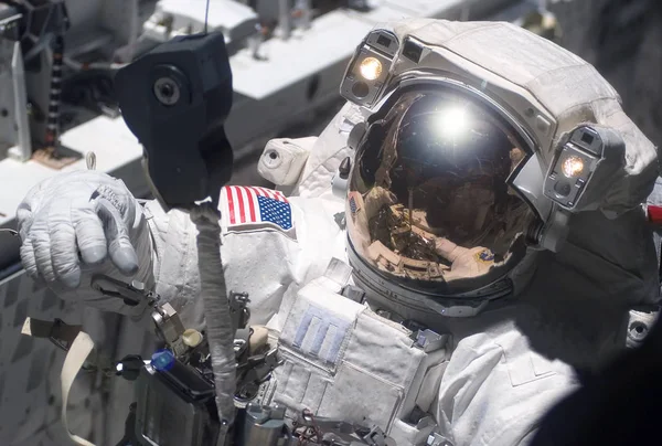 El astronauta en el traje espacial, en el espacio exterior, se ocupa de la reparación de la estación espacial. Elementos de esta imagen fueron proporcionados por la NASA —  Fotos de Stock